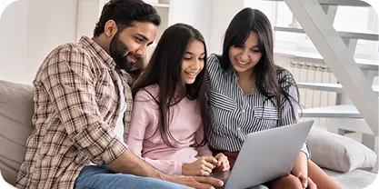 Family with teen girl looking at a laptop screen 